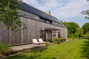 a metal building with two chairs on a patio at ParelDuyn in Oostkapelle