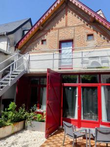 a house with a red door and chairs in front of it at L'Atelier des Rêves Amboise in Amboise