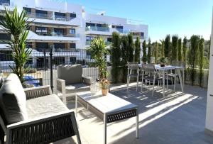 a patio with chairs and tables and a building at Xava Dreams Aire in Villacosta