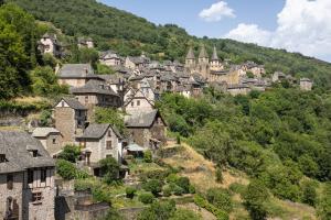 a village on a hill with a castle in the background at Gite Le Ginestou in Almon-les-Junies