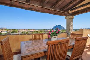 a wooden table and chairs on a balcony with a view at Il Balcone su Tavolara in Porto San Paolo