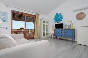 a living room with a white couch and a tv at Il Balcone su Tavolara in Porto San Paolo