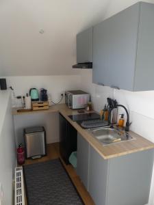 a small kitchen with a sink and a microwave at L'Atelier des Rêves Amboise in Amboise +19 photos