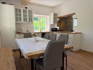 a kitchen with a table and chairs and a kitchen with white cabinets at Chalupa Hnízdo Jetřichovice in Jetřichovice