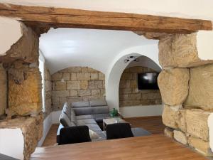a living room with a couch and a stone wall at Chalupa Hnízdo Jetřichovice in Jetřichovice +8 photos