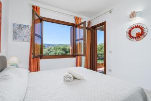 a bedroom with a bed and a large window at Il Balcone su Tavolara in Porto San Paolo +14 photos