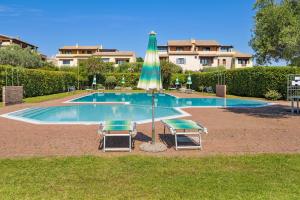 a swimming pool with two chairs and an umbrella at Il Balcone su Tavolara in Porto San Paolo