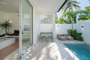 a room with a pool and a chair next to a house at Matahari House in Nusa Lembongan