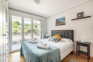 a bedroom with a bed and a large window at Ardantza Bidea - baskeyrentals in Zumaia