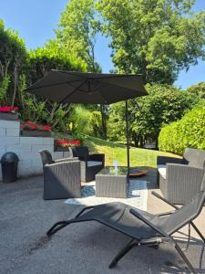 a patio with a table with an umbrella and chairs at Le Cosy Bu in Rochefort