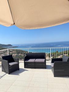 eine Terrasse mit zwei Stühlen und einem Sonnenschirm und das Meer in der Unterkunft Il Moro in Geremèas