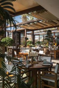 a dining room with tables and chairs and windows at Nikki Beach Resort & Spa Dubai in Dubai
