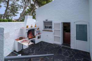 a white house with a fireplace in a patio at Torre Sant Genís in Llança