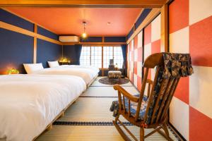 a room with two beds and a rocking chair at とれるの【TORERUNO】 in Takayama