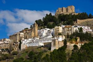 a group of buildings on a hill with a castle at Cortijo Mainacio in Siles