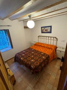 a bedroom with a bed with an orange blanket at Cortijo Mainacio in Siles