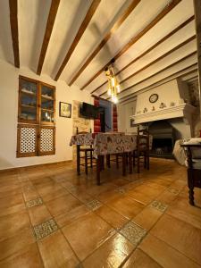 a dining room with a table and a fireplace at Cortijo Mainacio in Siles