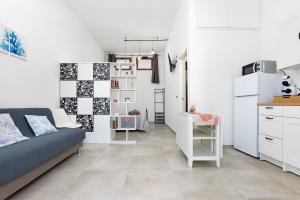 a living room with a couch and a kitchen at Appartamenti Corallo e Conchiglia in Olbia +29 photos