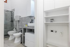a white bathroom with a toilet and a sink at Appartamenti Corallo e Conchiglia in Olbia