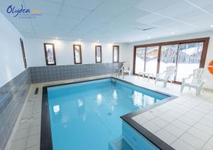 a large swimming pool with blue water in a room at Olydea les Bottieres - Saint-Pancrace in Saint-Pancrace