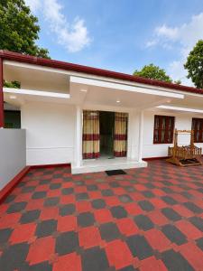 a house with a red and black checkered floor at JB Vin Hotel in Point Pedro