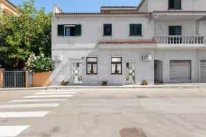 an empty parking lot in front of a white house at Appartamenti Corallo e Conchiglia in Olbia