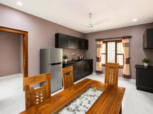 a kitchen with a table and a refrigerator at JB Vin Hotel in Point Pedro