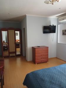a bedroom with a bed and a dresser and a tv at Casablanca Hotel in Kalush