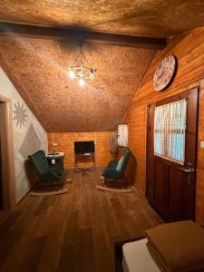 a living room with two chairs and a clock on the ceiling at Blue Eye Villas in Sarandë