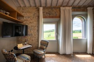 a room with a table and chairs and a window at Locanda dei Logi in San Gimignano