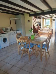 a kitchen and dining room with a table and chairs at La Croix Gîtes in Pressignac