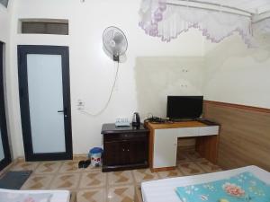 a room with a desk with a computer and a lamp at Nhà nghỉ Homestay Minh Hạnh in Nà Phia