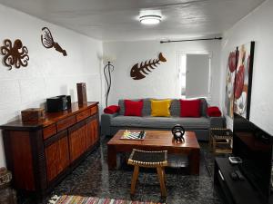 a living room with a couch and a table at Maison bord de mer Calypso in Punta Mujeres