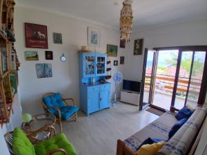 a living room with a couch and a blue cabinet at boundless horizon potidea in Nea Potidaea