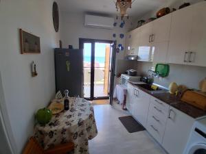a kitchen with a table and a refrigerator at boundless horizon potidea in Nea Potidaea