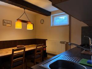 a kitchen with a wooden table and a counter top at Chalupa 387 in Harrachov