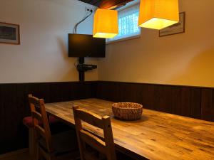 a wooden table with two chairs and a basket on it at Chalupa 387 in Harrachov