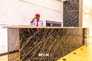 a man is standing behind a reception desk at Geo38 Premium Suites Genting Highlands by BYON in Genting Highlands