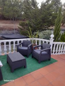 a patio with two chairs and a table on a green rug at cupido feeling nomad in Souro Pires