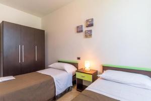a bedroom with two beds and a night stand with a lamp at Residence Albarella in Isola Albarella +165 photos