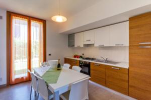 a kitchen with a white table and white chairs at Residence Albarella in Isola Albarella
