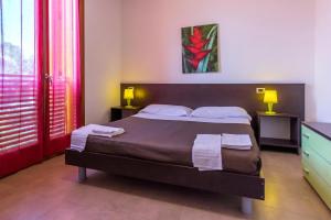 a bedroom with a bed with two towels on it at Residence Albarella in Isola Albarella