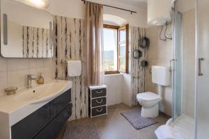 a bathroom with a sink and a toilet and a window at Residence Panorama in Buzet