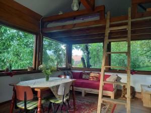 a living room with a loft bed and a table at Bungalow Maria&Razvan in Pângărăcior