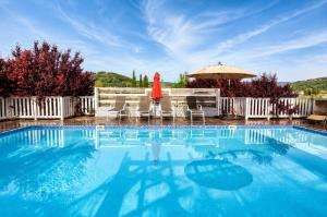 a large swimming pool with an umbrella and chairs at וילה מקסים בחוסן - וילה מהממת עם בריכה, ג'קוזי וסאונה in H̱osen +15 photos