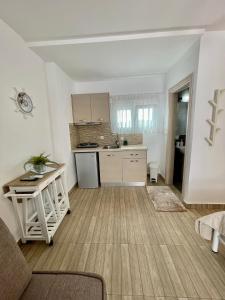 a living room with a kitchen and a room with a couch at Alkyonari By Maria in Ammouliani