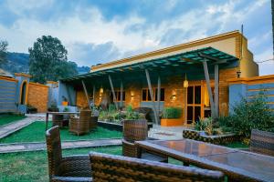 a house with a patio with a table and chairs at Neriah Suites in Kabale