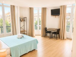 a bedroom with a bed and a table with chairs at Résidence Appartement Adonis in Nice