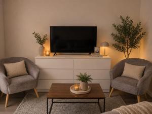 a living room with two chairs and a flat screen tv at Plekkenpolhof in Enschede