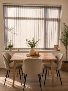 a dining room table and chairs with a window at Plekkenpolhof in Enschede +1 photo